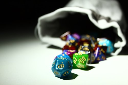 polyhedral dice rolling out of a dice bag