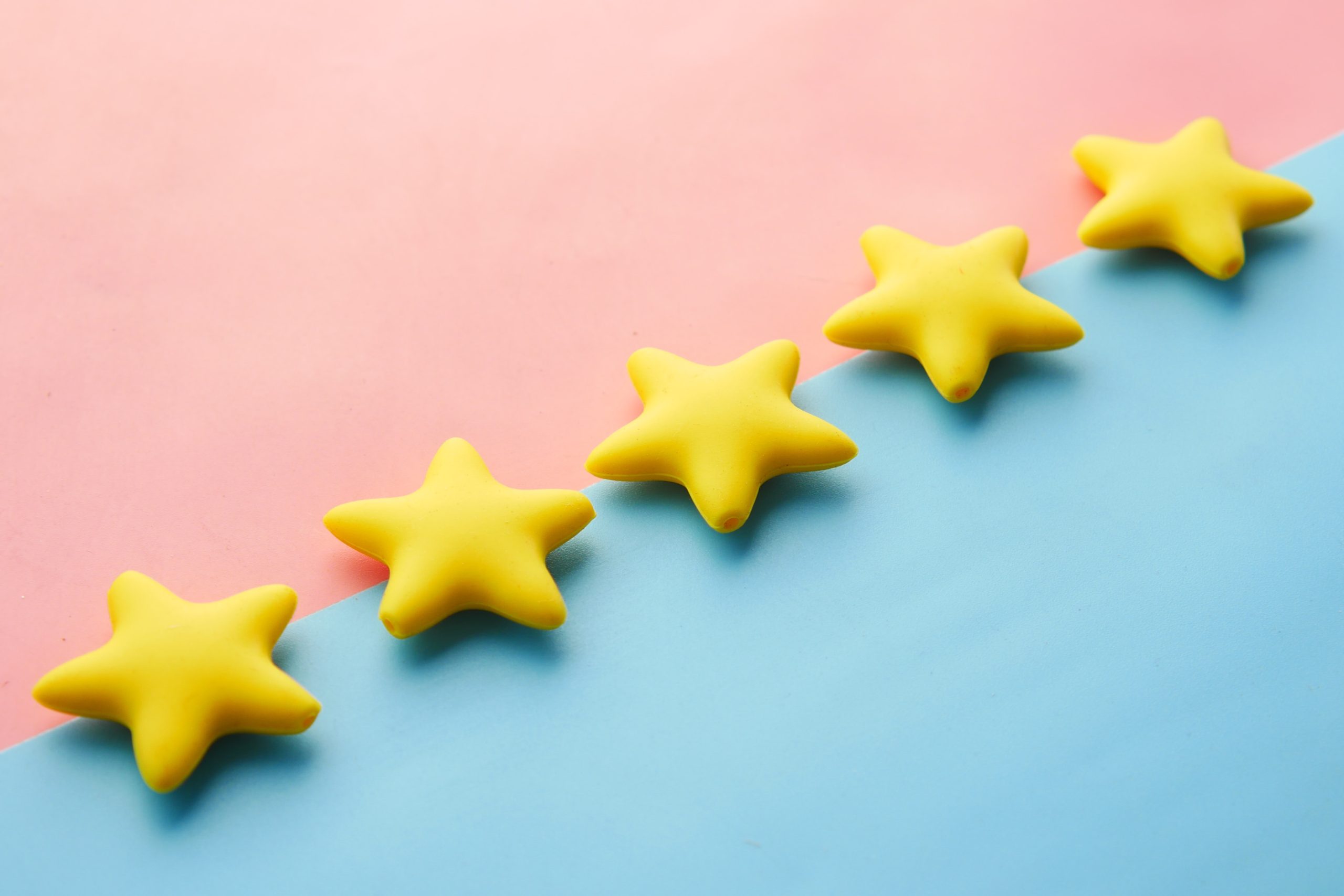 five yellow paper stars on blue and pink paper background