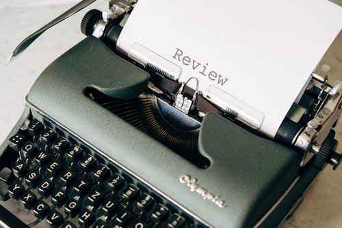 manual typewriter with the word "review" on a working piece of paper