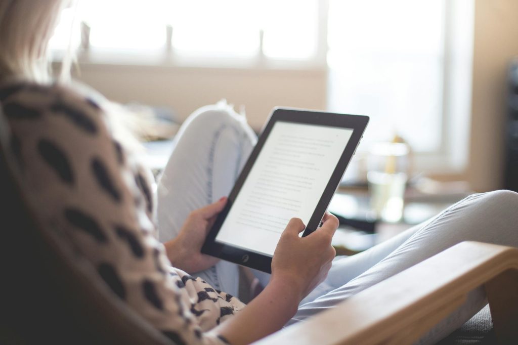 woman sitting on chair using black ipad